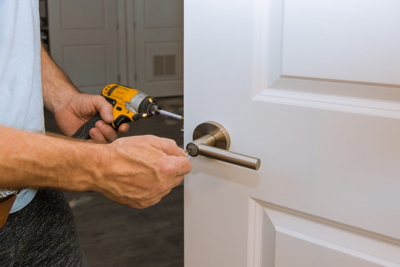 installation-of-the-door-lock-interior-door-woodworker-hands-install-locked